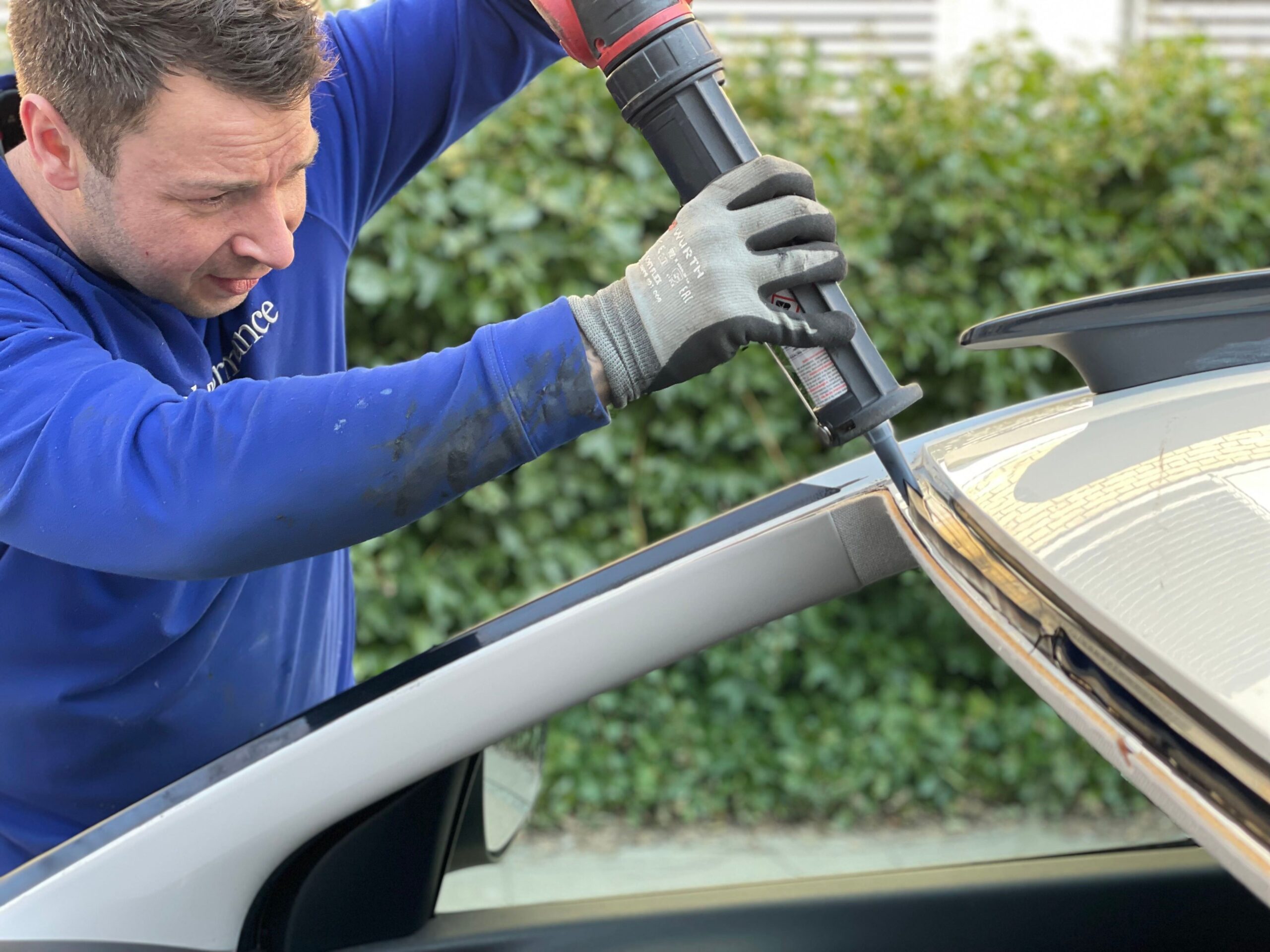 A Professional applying an Adhesive Glue for a Windscreen Replacement