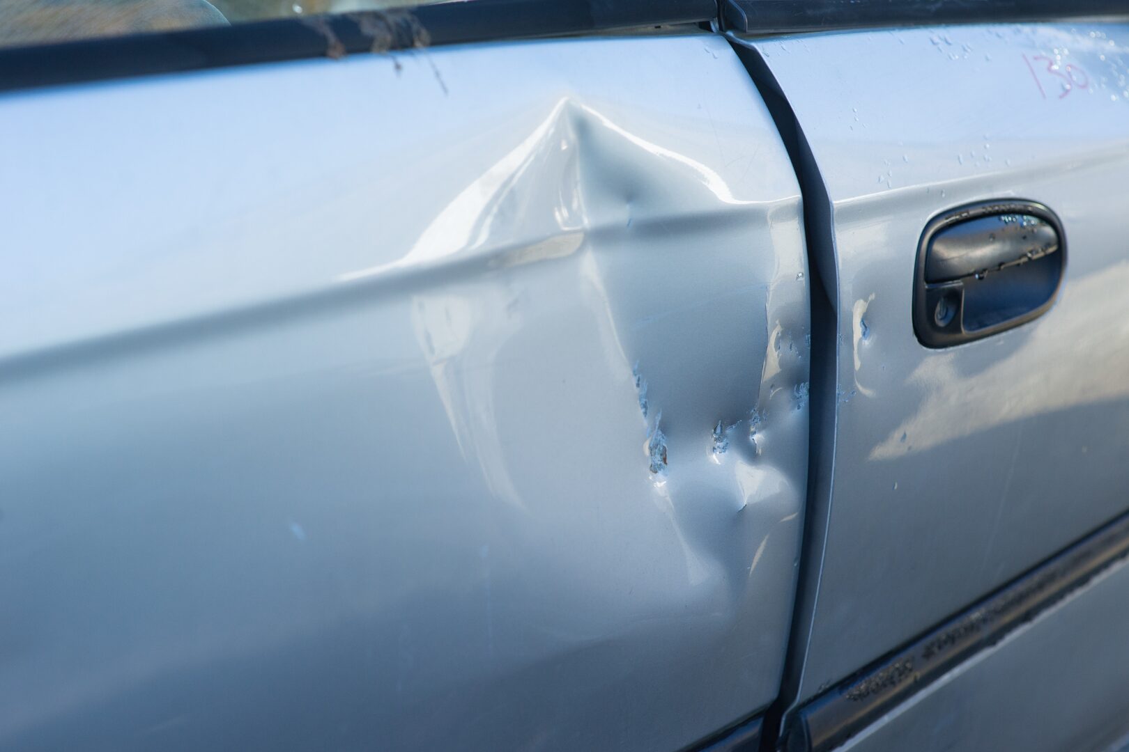Multiple dents accumulated across a vehicle's door panel
