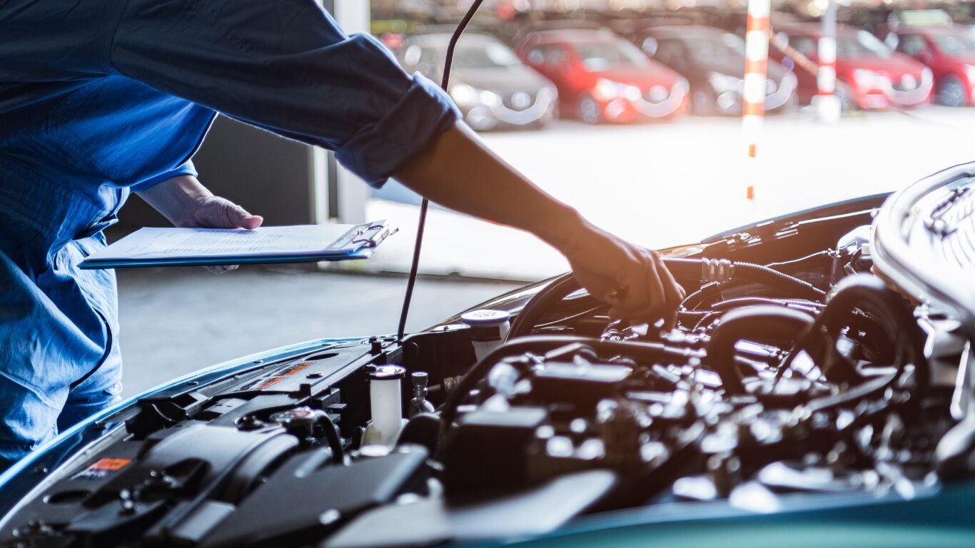 Expert panel beater inspecting a damaged vehicle to decide whether to repair or replace car parts.