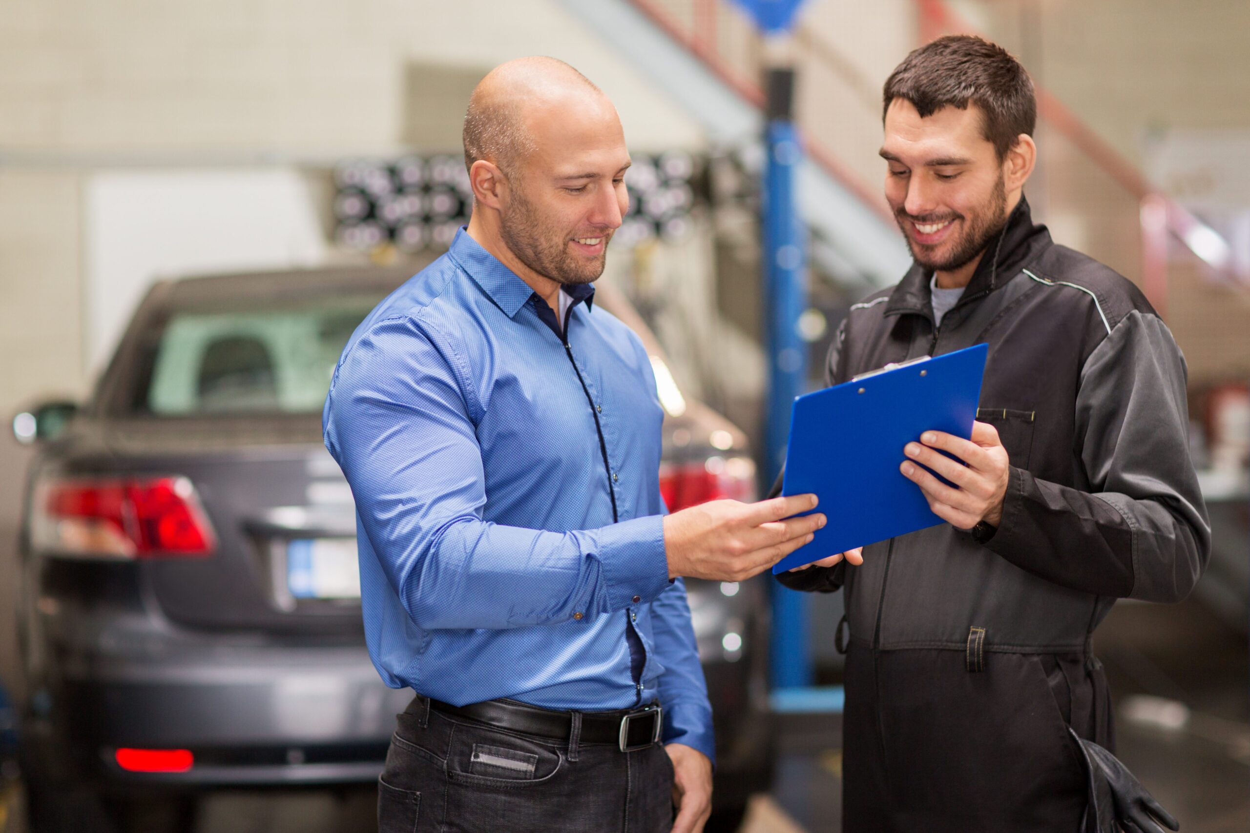 Panel beaters Sandton, business driver reviewing an itemised company car repair quote with a technician.