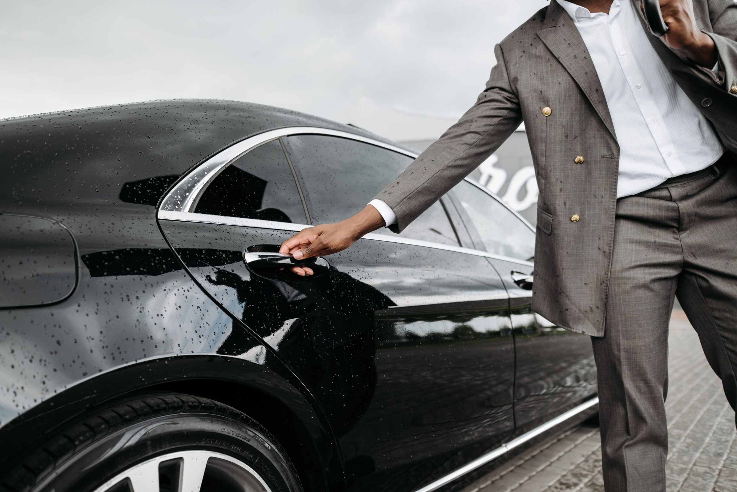 Panel beater in Sandton guide for company car drivers, business driver opening a black company car.