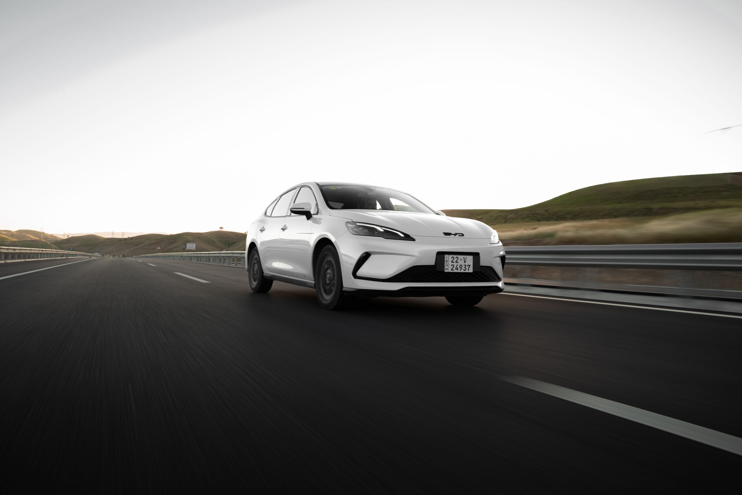 White BYD sedan on the highway, pearl white paint that needs expert colour matching.