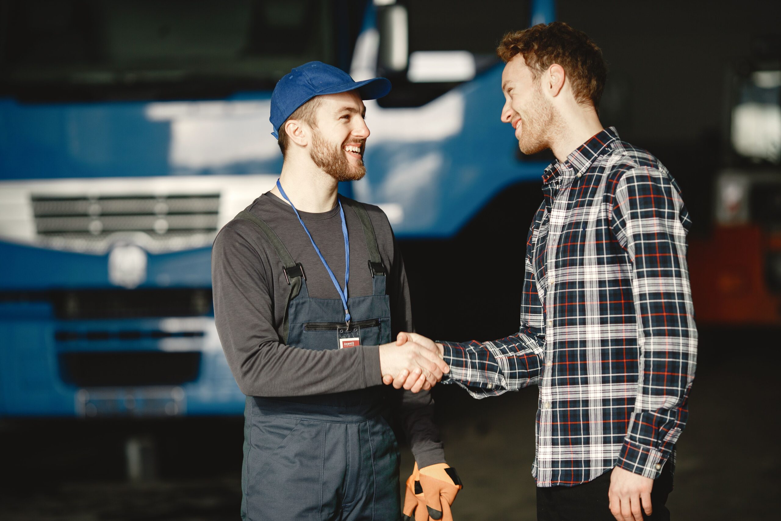 Panel beater near me shaking hands with a customer after a pothole damage repair assessment.